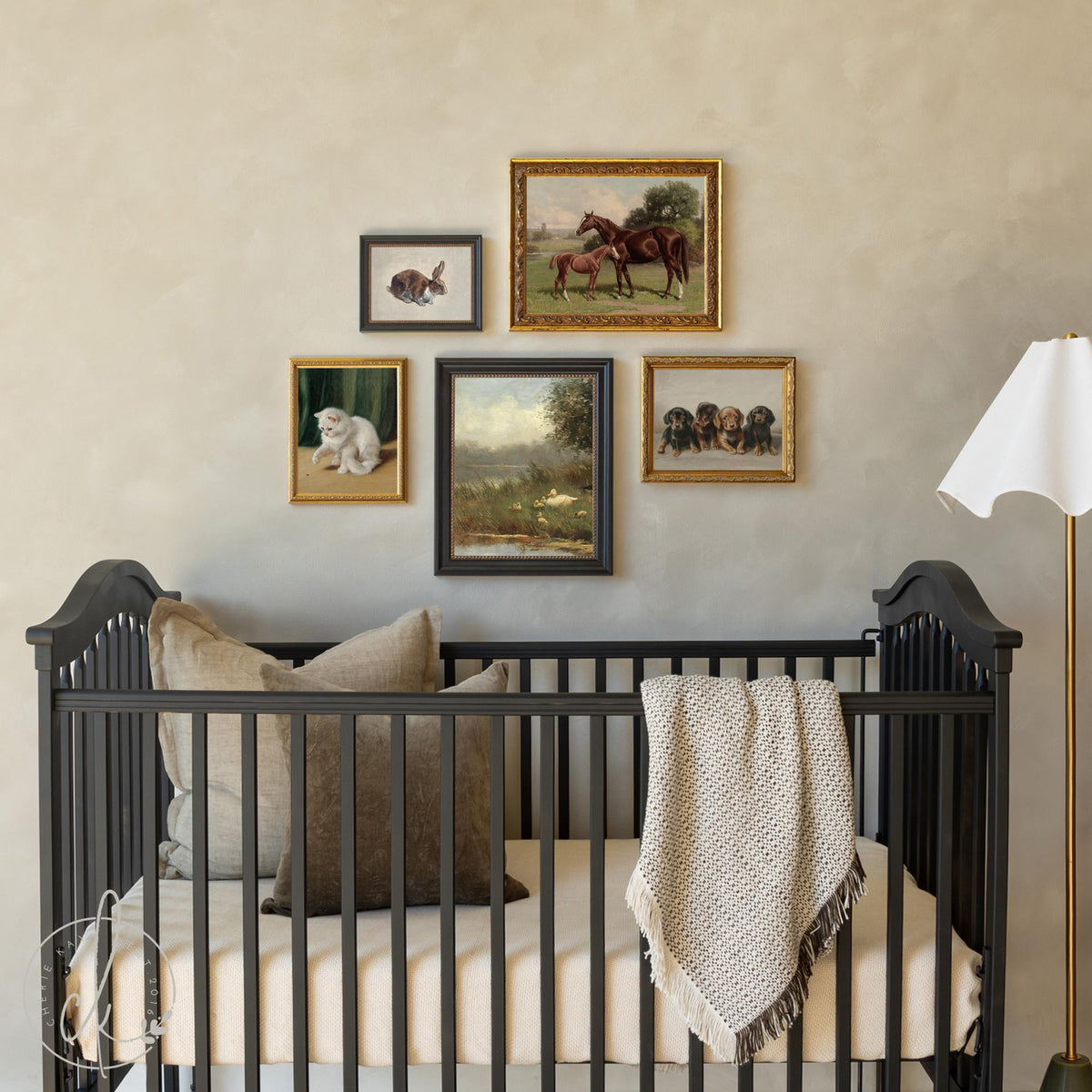 Framed nursery gallery wall with vintage animal prints above a baby crib in soft neutral tones.