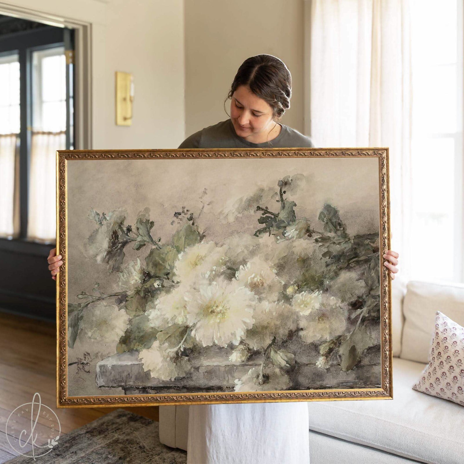 Antique gold framed vintage botanical wall art featuring a large white-flower painting displayed above a black sideboard in a modern living room.