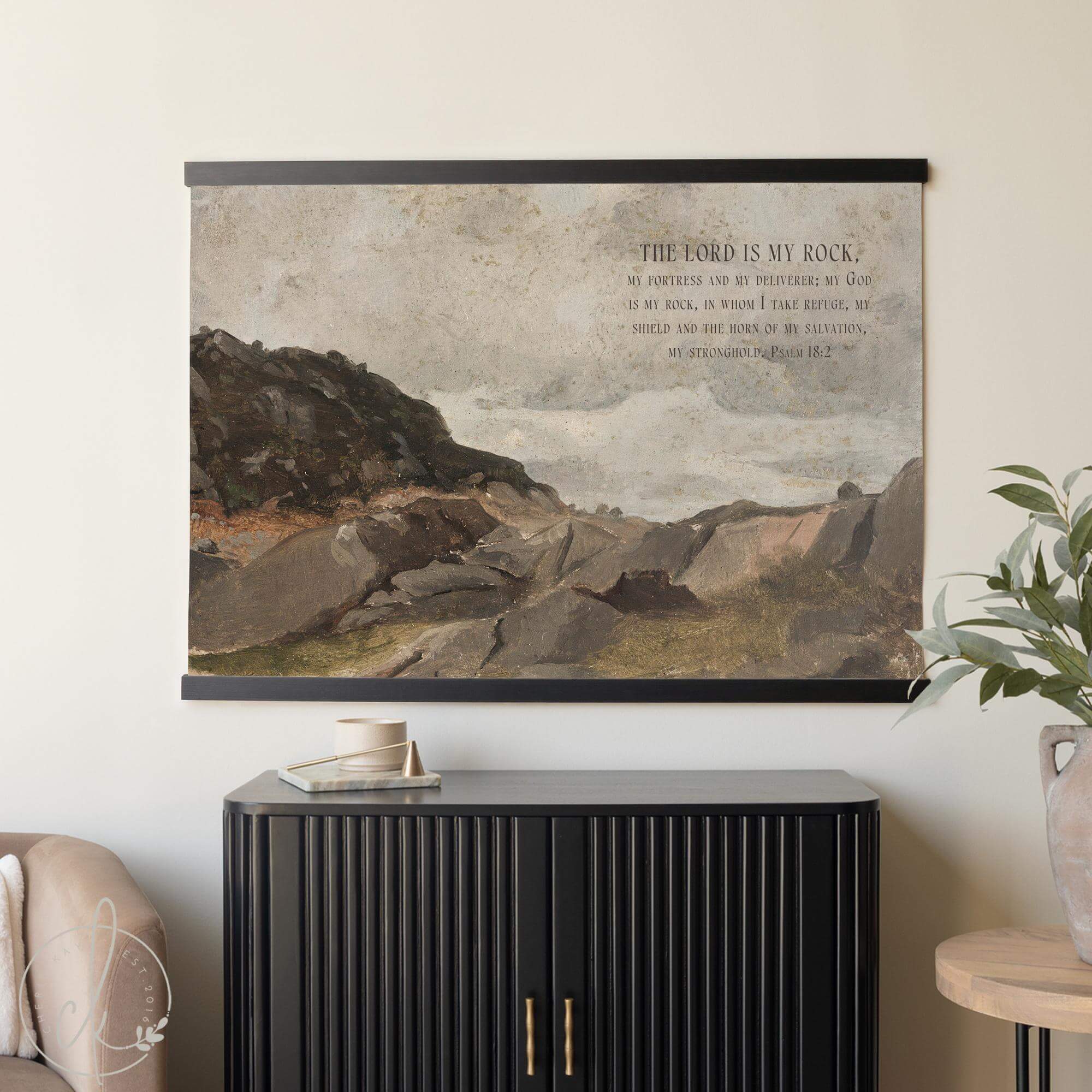 Vintage oil painting wall art featuring a rocky landscape and Psalm 18:2 scripture, styled as neutral Christian wall decor above a modern black console.