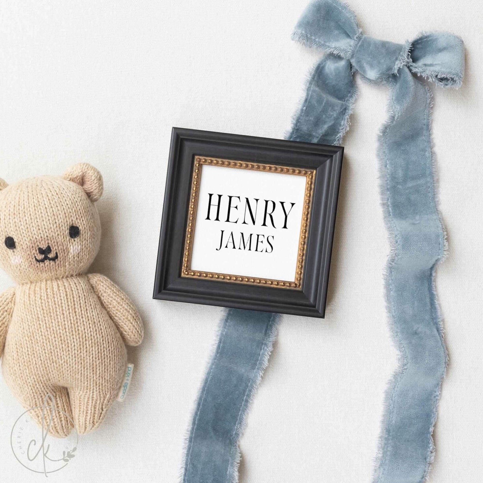 Newborn photo prop featuring a personalized baby boy name sign in a black beaded-edge frame, styled with optional month milestone cards for hospital and nursery decor.
