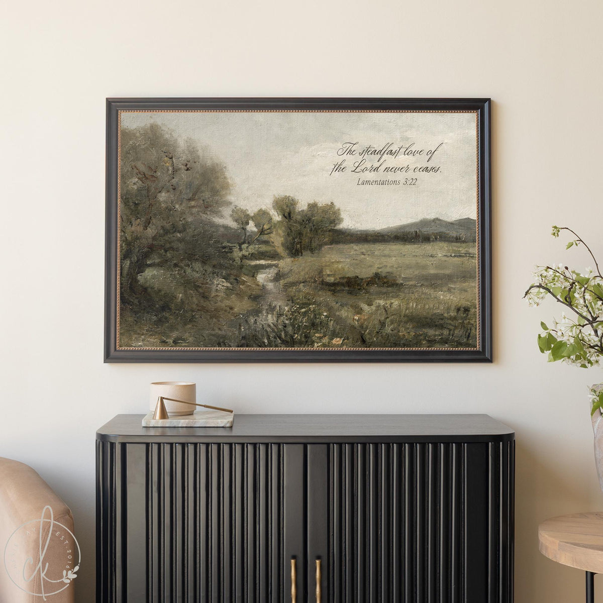 Wall art with scripture featuring vintage landscape painting and Lamentations 3:22 verse about steadfast love in ornate frame