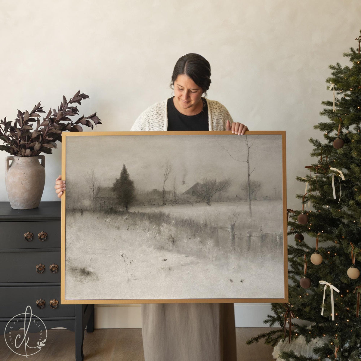 Framed snowy landscape painting in neutral tones, large winter wall art with trees and farmhouse.