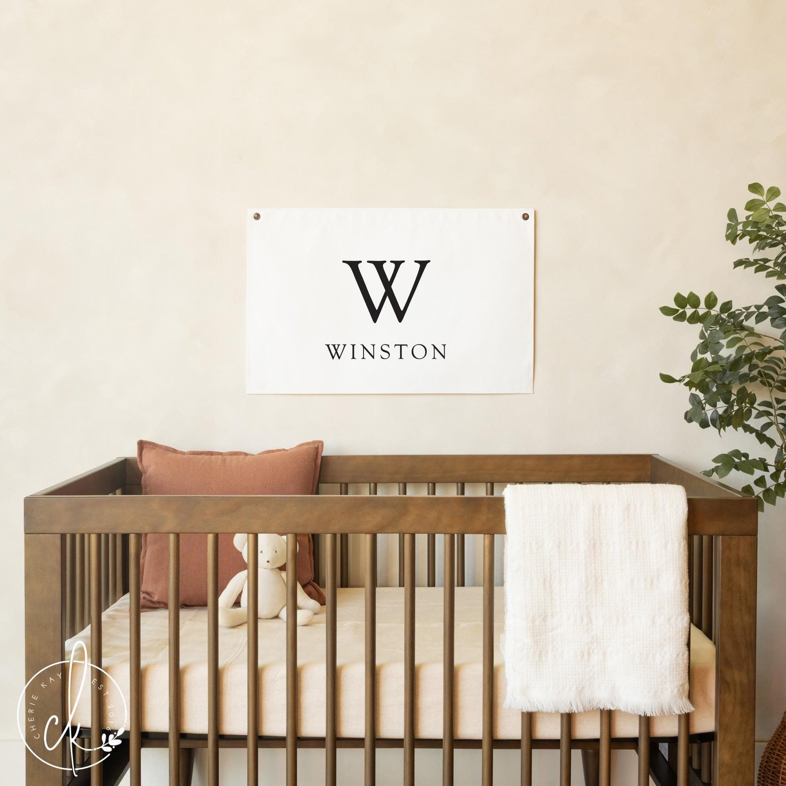 Personalized nursery name banner with baby’s initial and name on neutral canvas wall hanging.
