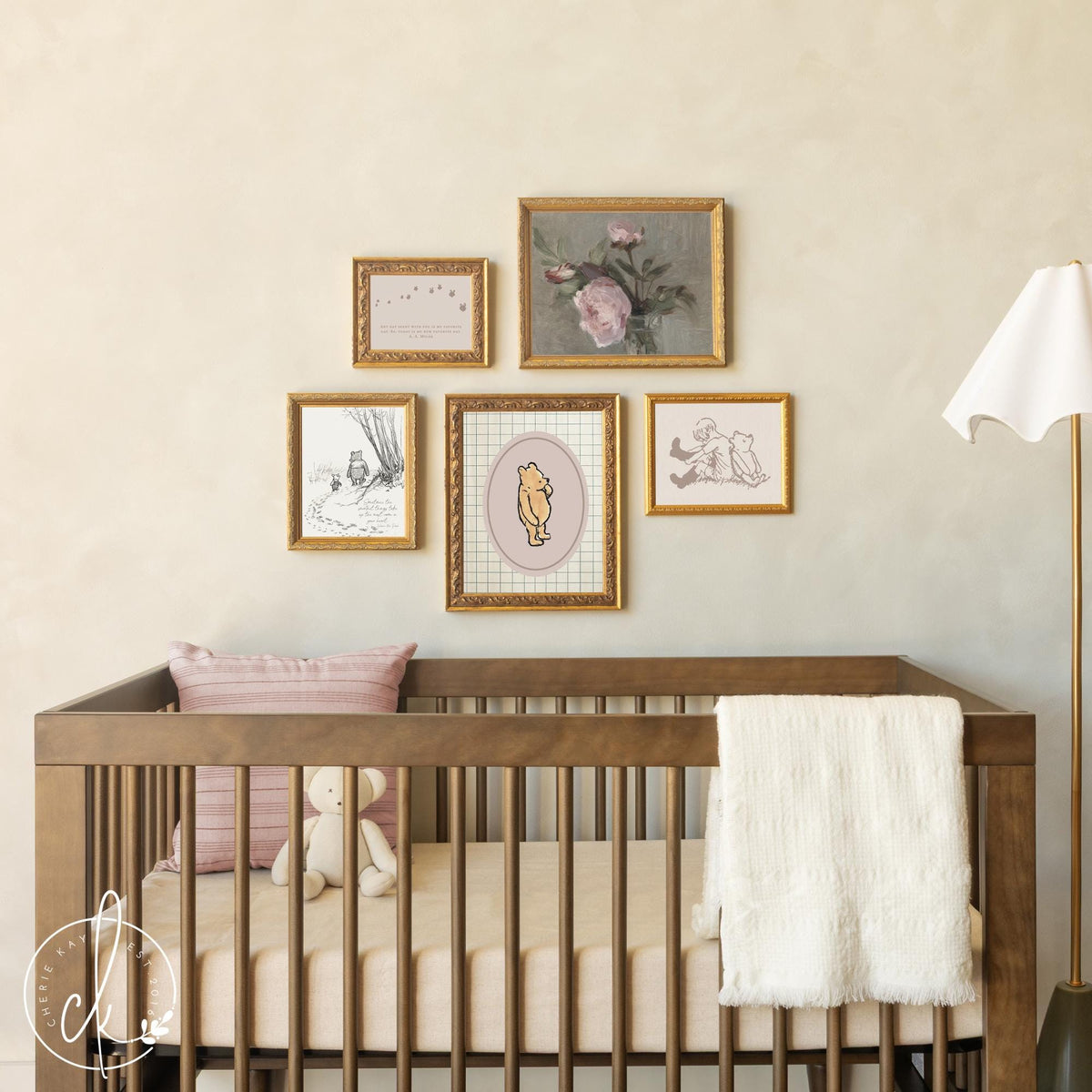 Winnie the Pooh nursery wall art with gold frames above baby crib in neutral nursery.