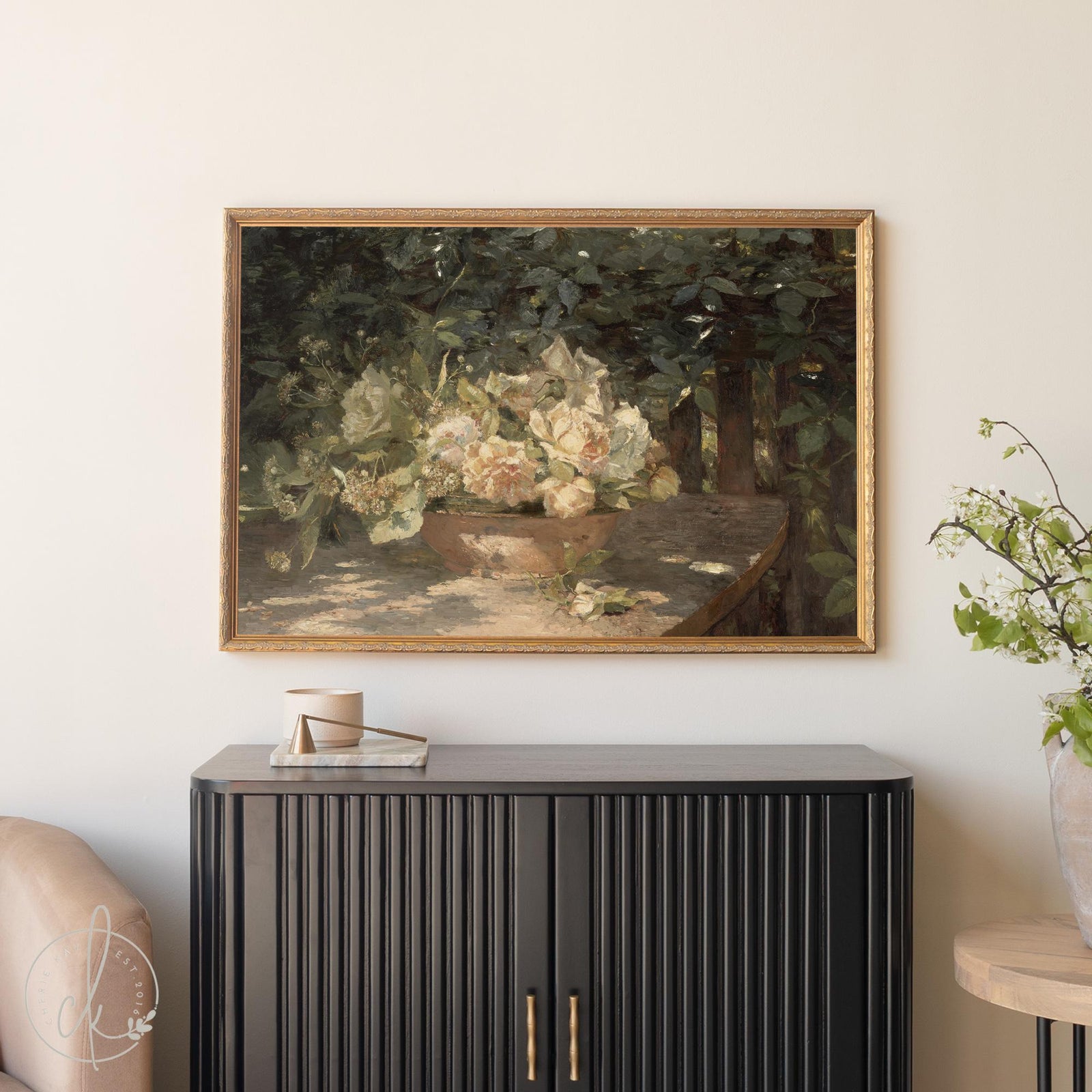 Antique botanical art print with flowers in gold frame above black cabinet.