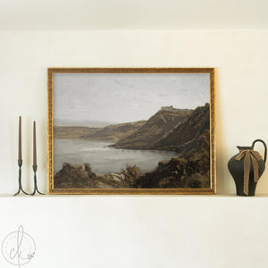 Framed vintage coastal art with gold frame and calm water landscape over cliffs.