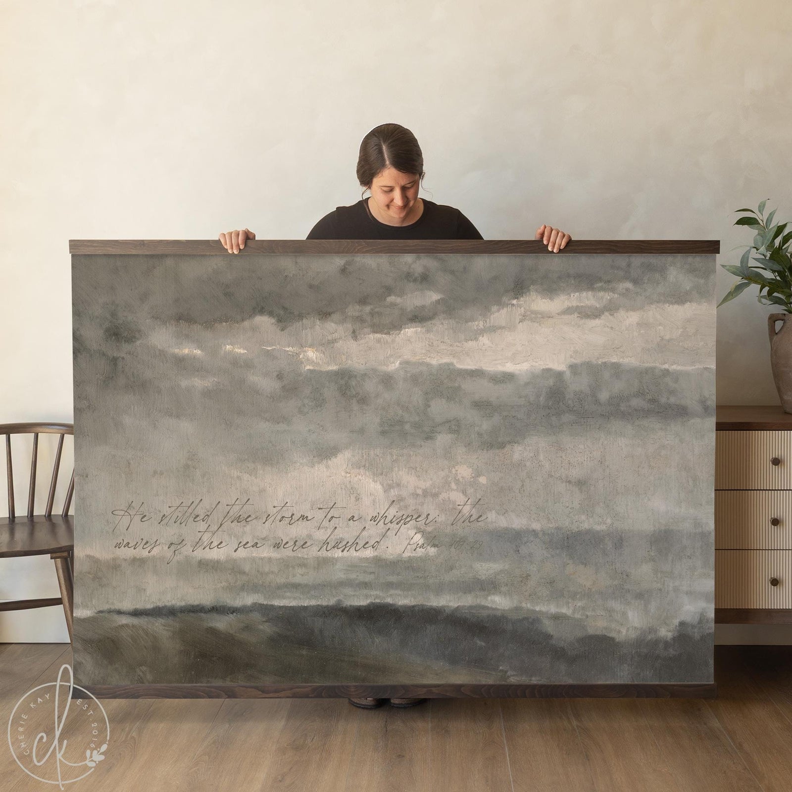 Moody landscape art canvas tapestry with Psalm 107:29 verse over a stormy impressionist ocean seascape in muted tones.