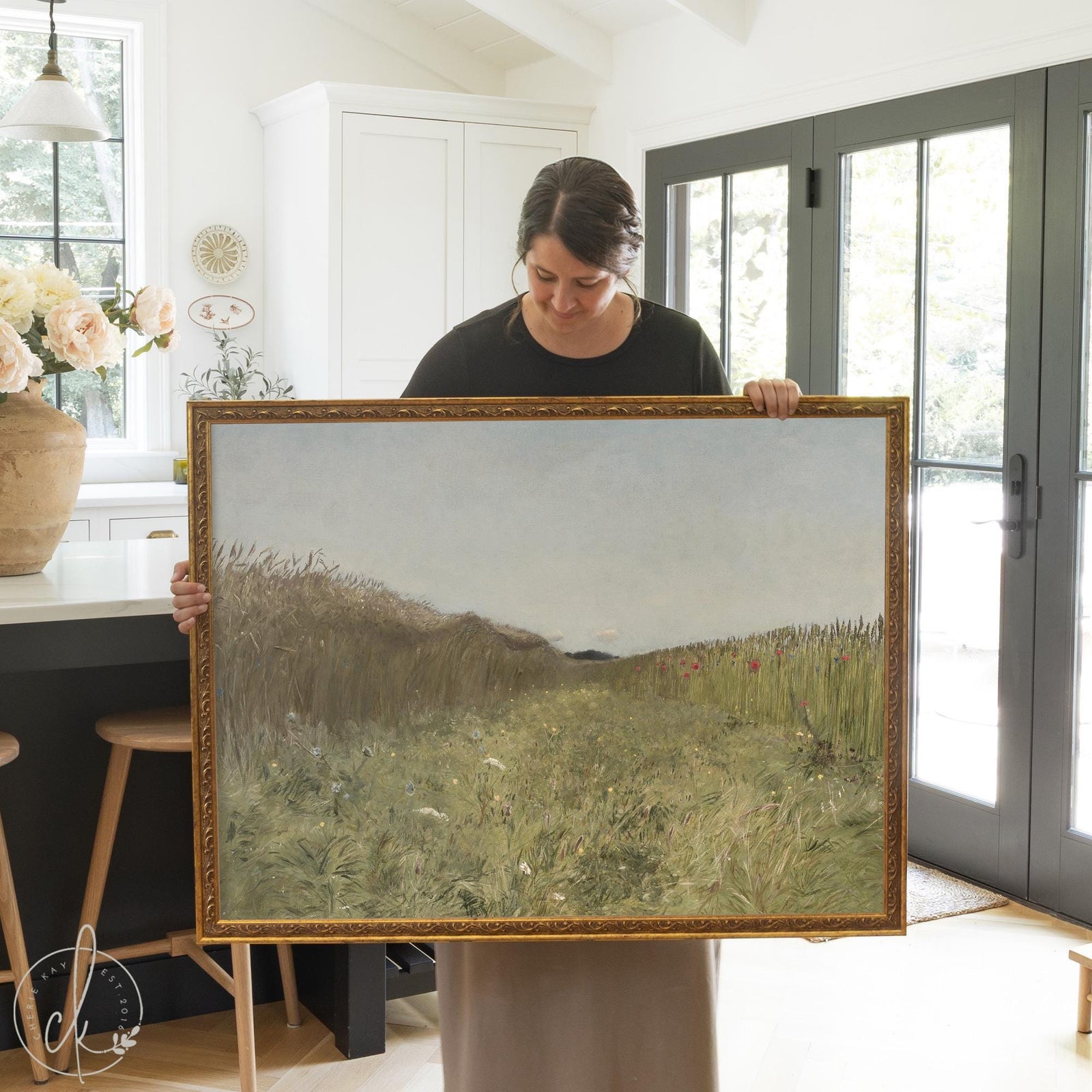 Framed landscape art of a countryside meadow with wildflowers and soft sky.