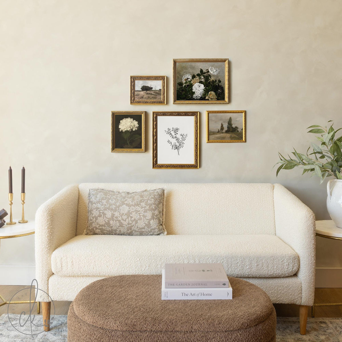 Vintage gallery wall set with gold frames featuring floral and botanical wall art above a cream sofa.