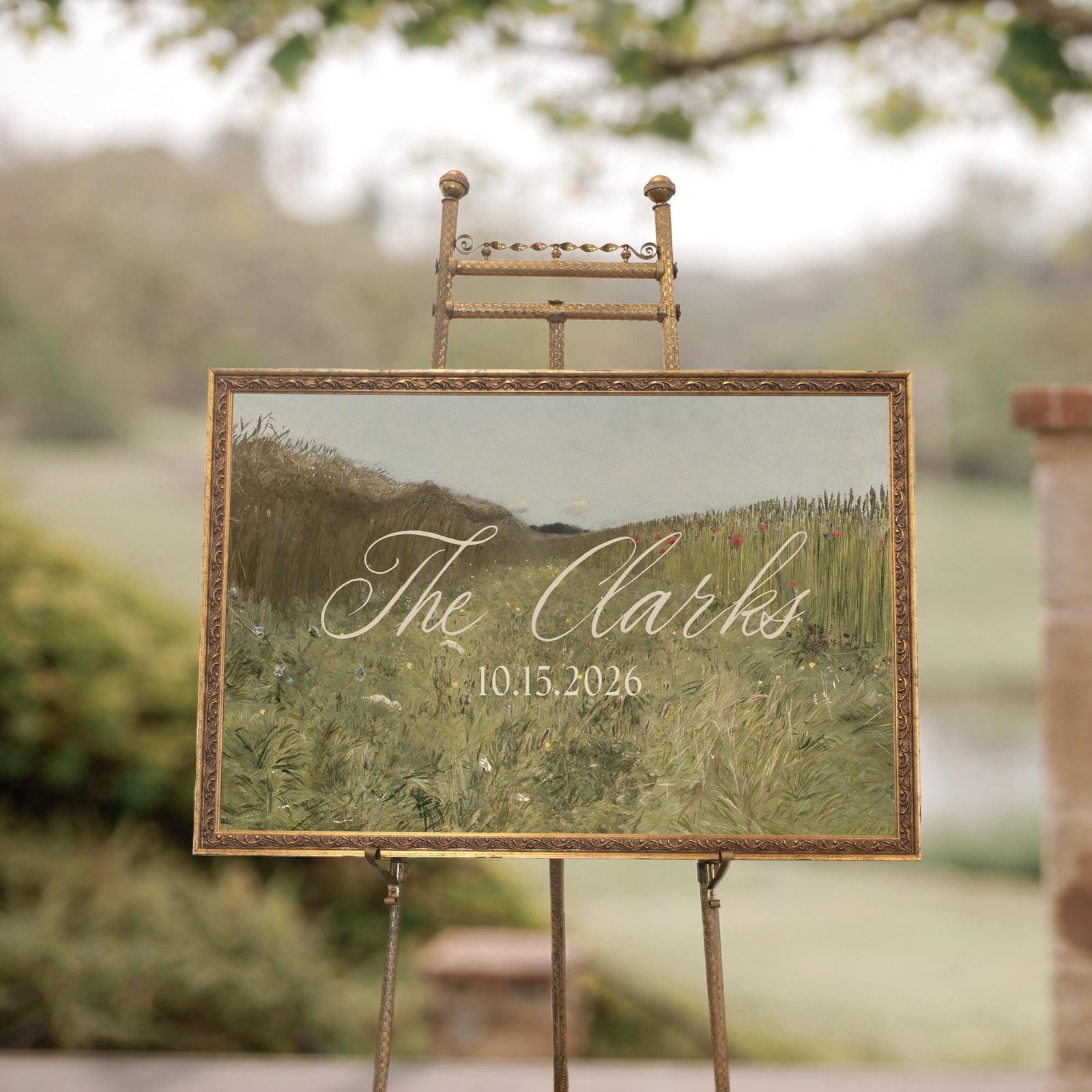 Wedding last name sign with wildflower landscape in ornate gold frame on ceremony easel
