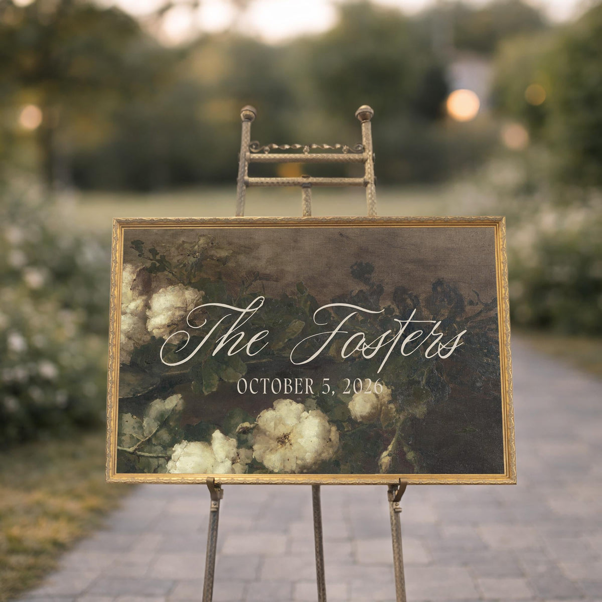 Personalized wedding last name sign with dark floral painting in antique gold frame on easel