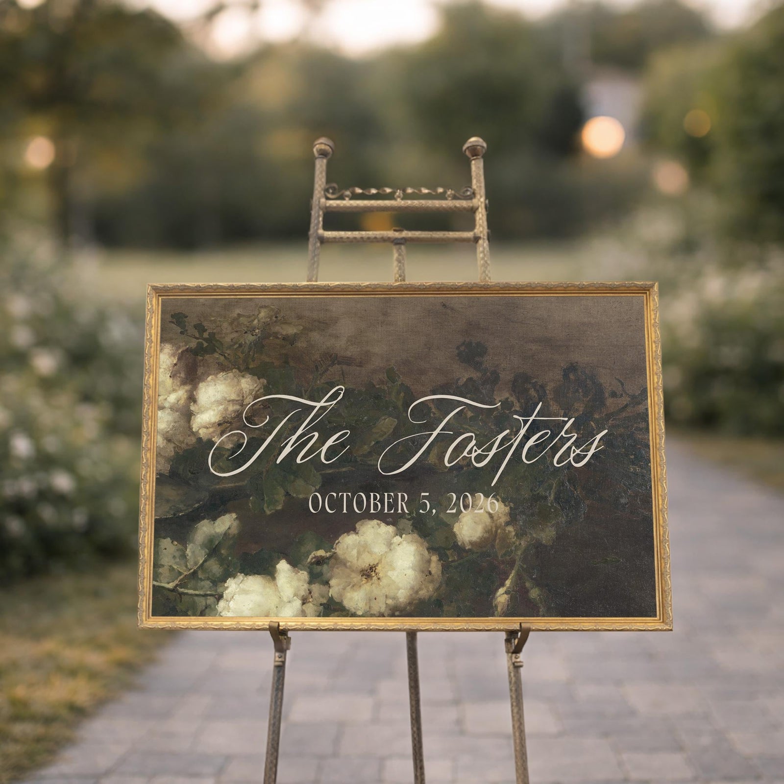 Personalized wedding last name sign with dark floral painting in antique gold frame on easel
