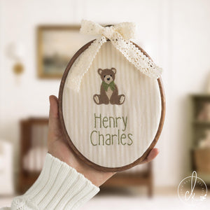 Teddy bear embroidery hoop art with personalized baby name and lace bow on cream striped fabric