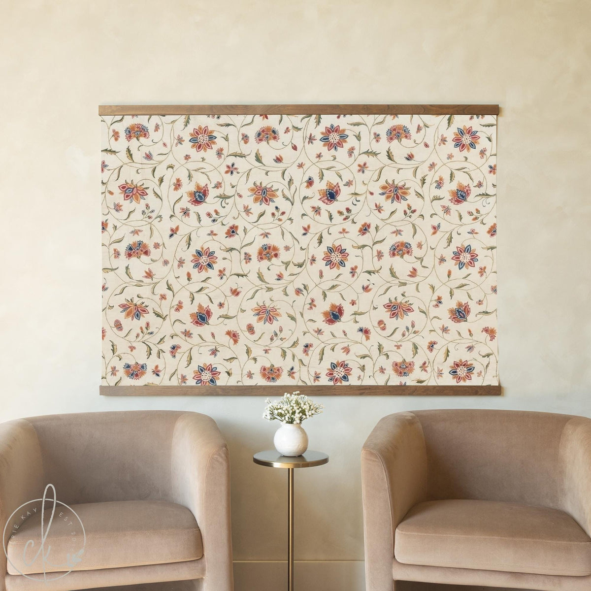 Floral tapestry wall hanging with terracotta and navy blooms on cream, hung above seating in a living room.