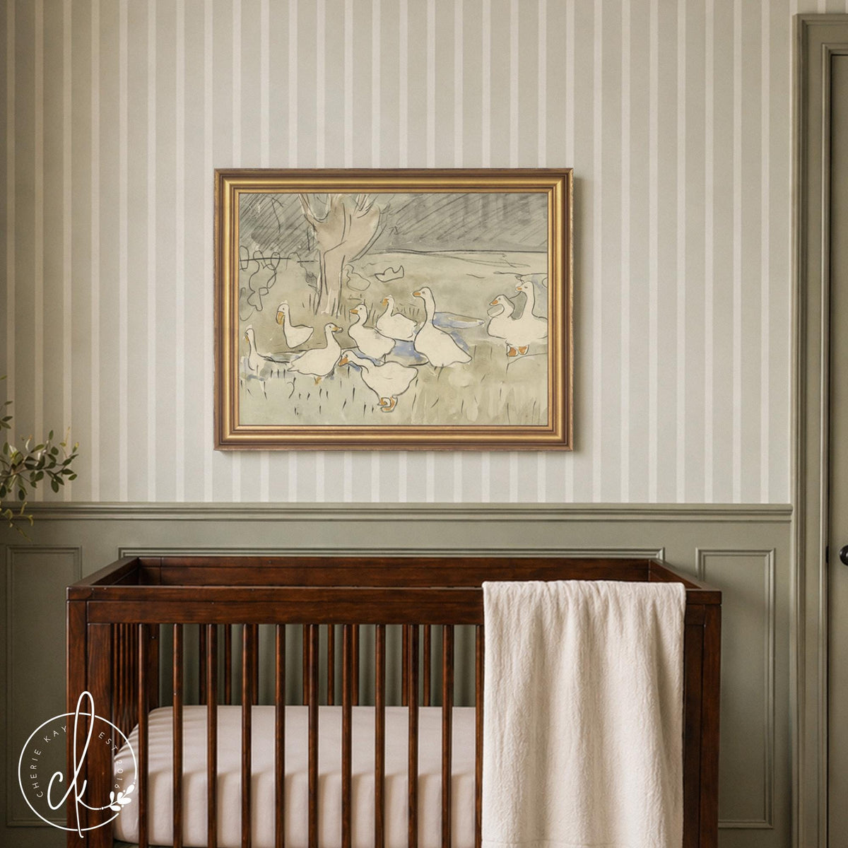 Vintage goose nursery decor canvas showing white geese in a sage green field, in a gold frame above a dark wood crib