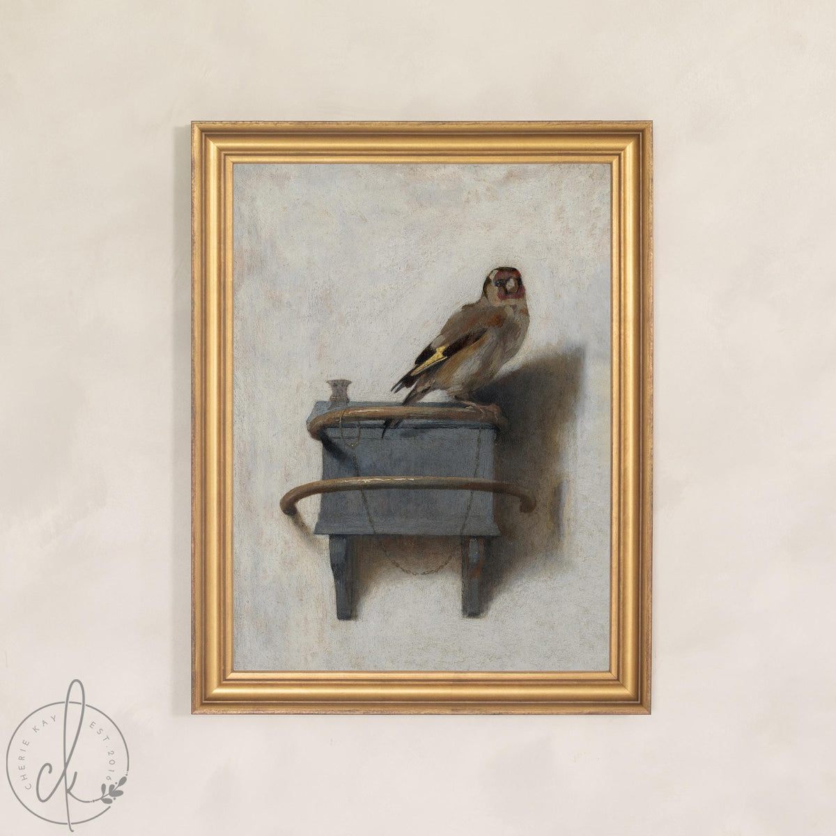Vintage bird art: framed canvas print of a goldfinch perched on a small wooden feeder box, gold frame.