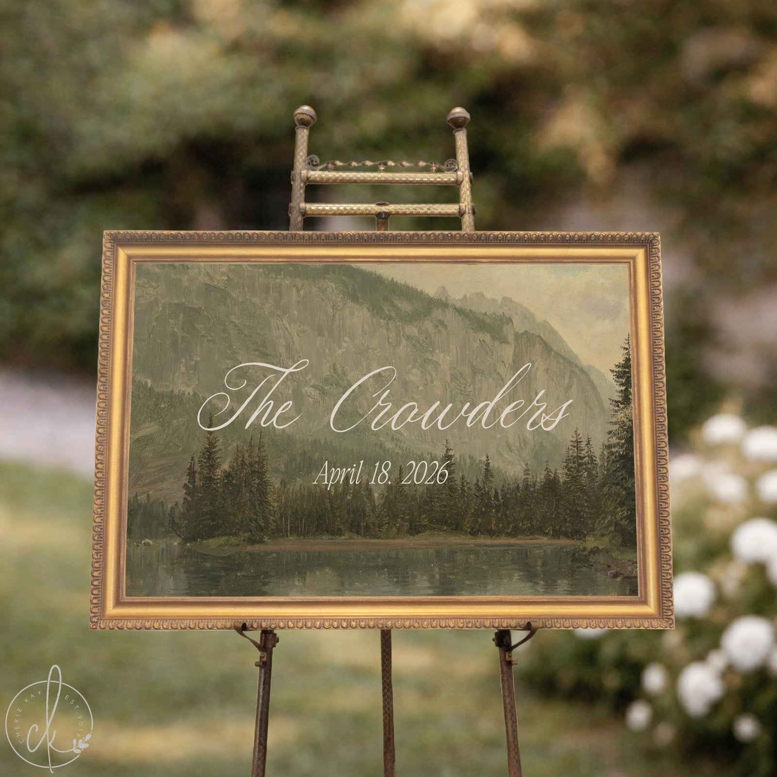 Last name wedding sign with a vintage mountain lake painting in a gold frame on an easel