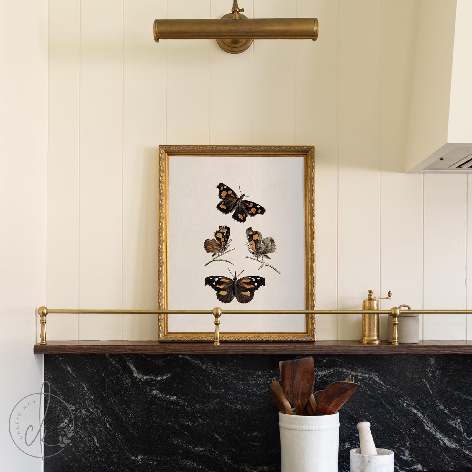 Framed butterfly art with four vintage butterfly and moth specimens on cream in a gold frame