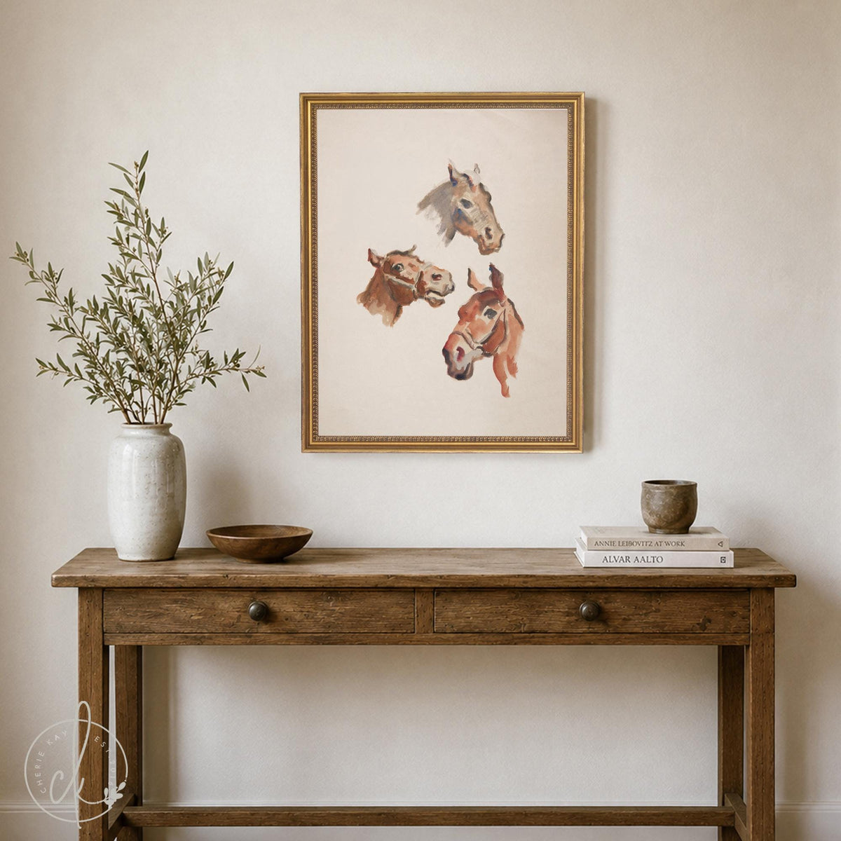 Horse print with three vintage horse head studies on cream in a gold frame above a wood table