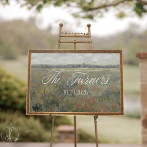 Wedding established sign with a last name and date over a vintage wildflower meadow in an ornate gold frame.