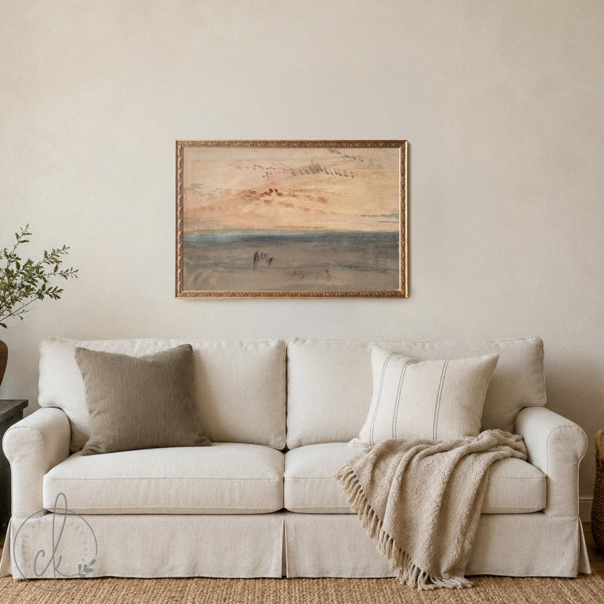 Abstract watercolor ocean sunset painting in an ornate gold frame, pale peach sky over a soft sand shoreline.