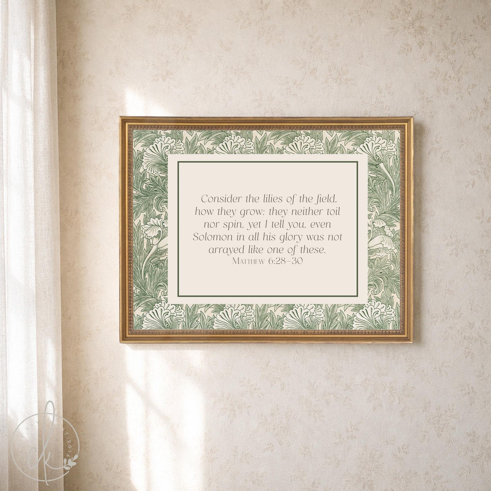 William Morris print of Matthew 6:28-30 on a cream panel inside a green botanical border and gold frame on a light wall