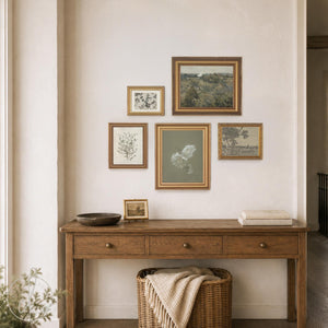 Vintage gallery wall sets of 5 gold framed canvas prints with landscape, botanical, and floral art above a wood console.