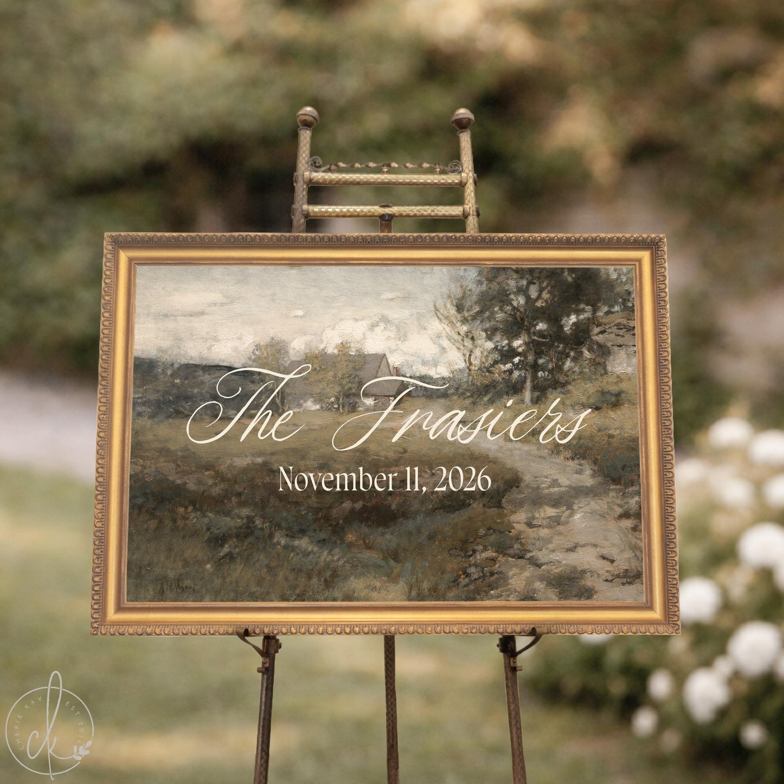 Wedding ceremony welcome sign on an easel, gold framed vintage landscape canvas with script last name and wedding date
