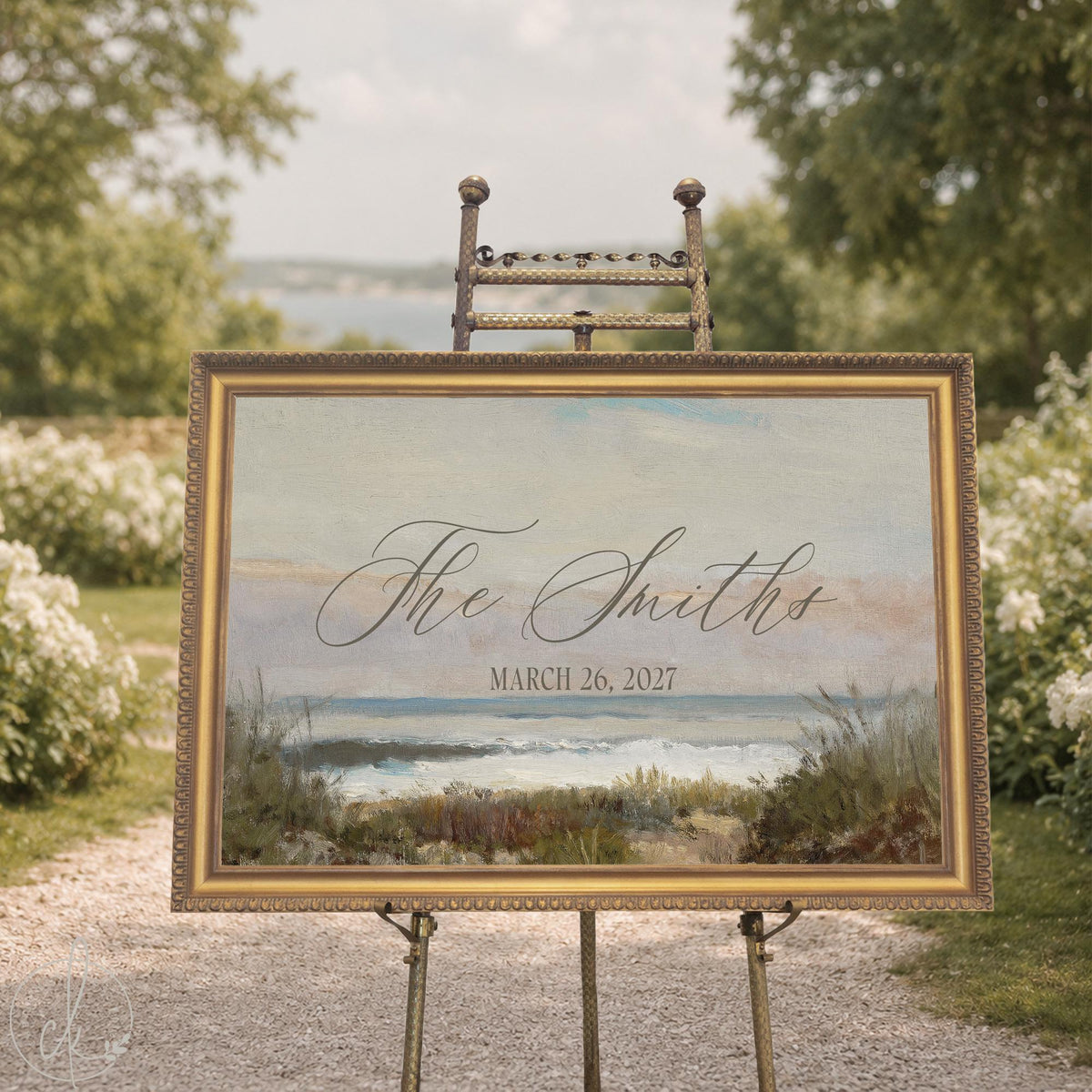 Beach wedding decor sign with a vintage seascape canvas in an ornate gold frame on a brass easel, script last name and date.