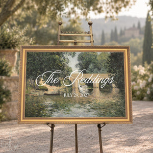 Personalized home sign with a family name and wedding date in white over a stone bridge river scene in an ornate gold frame