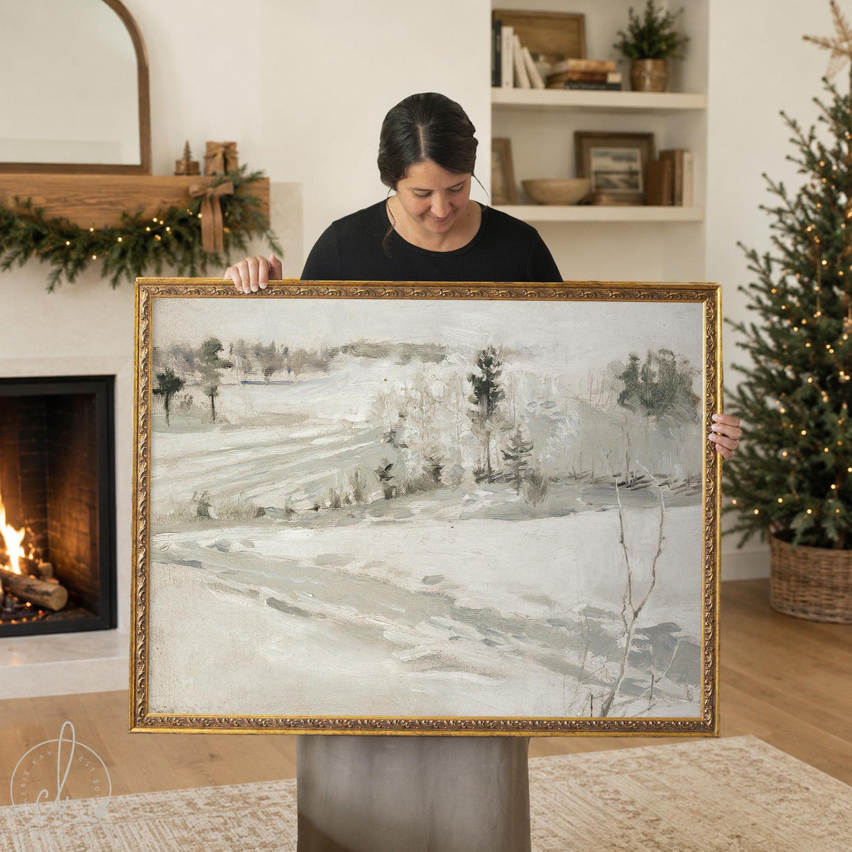 Country Christmas decor snowy hillside landscape canvas print in an ornate gold frame, held up in a living room