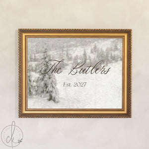 Christmas wedding decor sign with a family name and est. year over a snowy pine hillside in an ornate gold frame