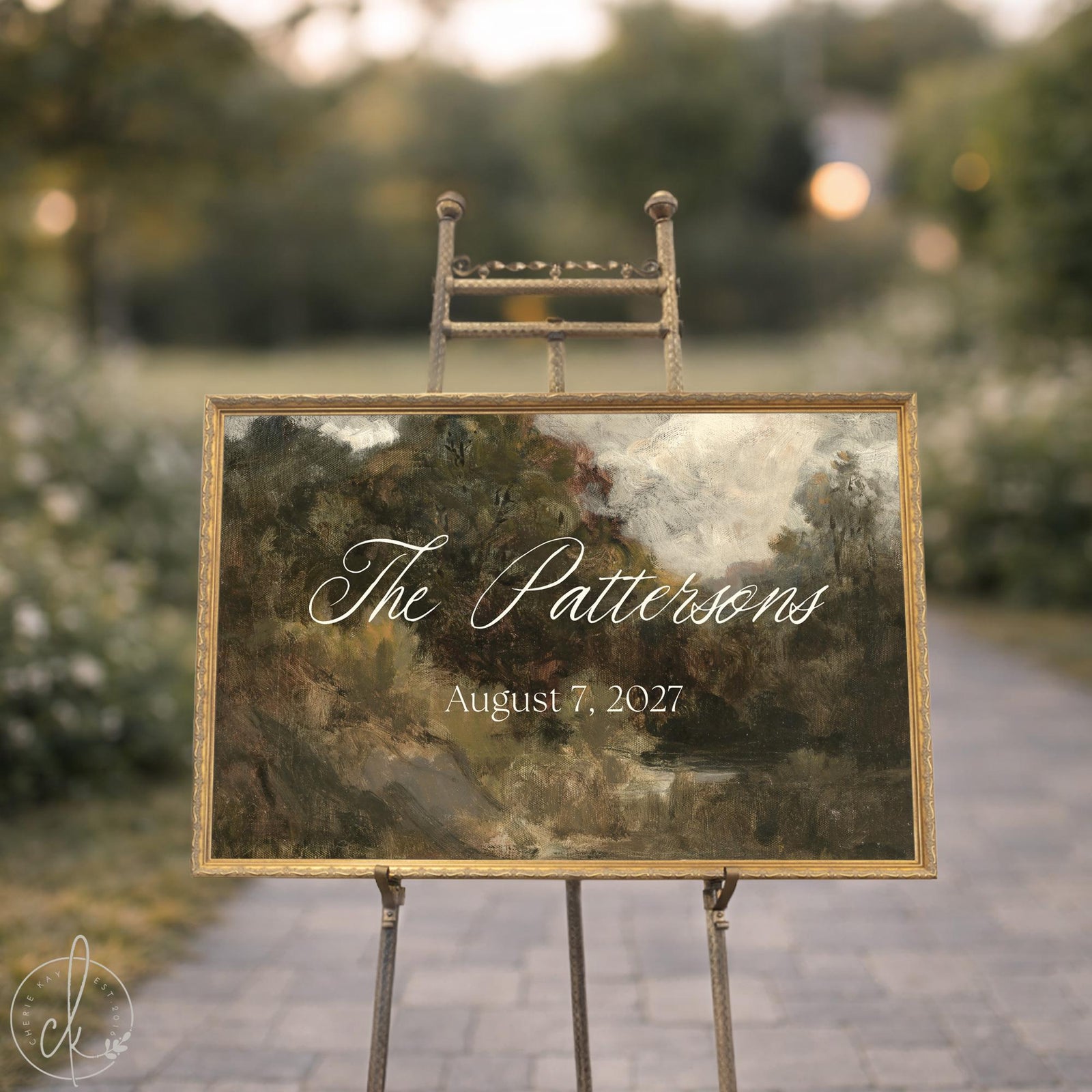 Personalized housewarming gift sign with a last name in white script over a landscape painting in an ornate gold frame