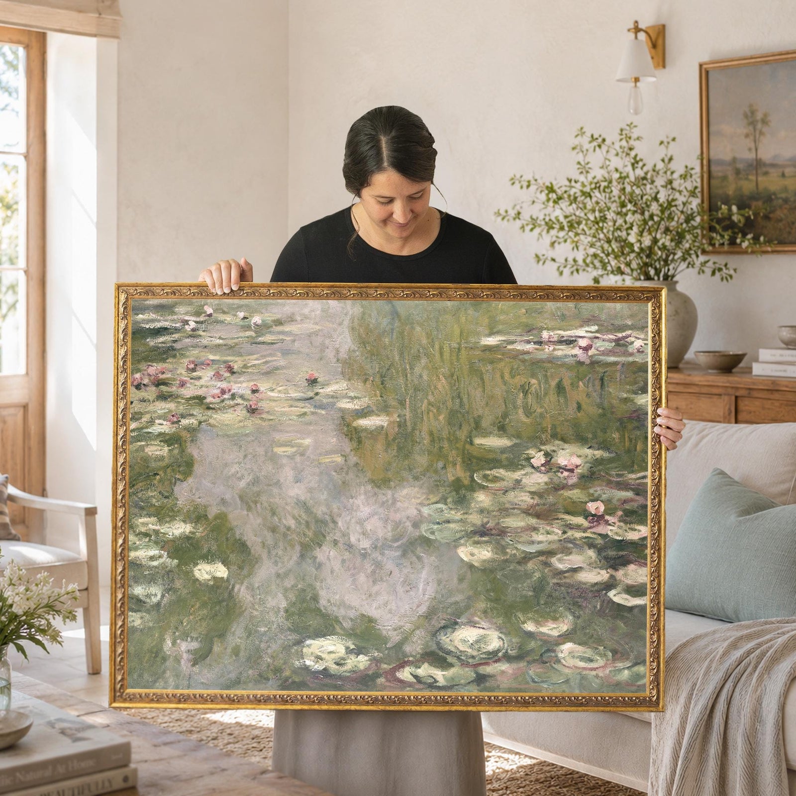 Monet lily pads print in an ornate gold frame, pink water lilies on a soft green pond, held up in a living room