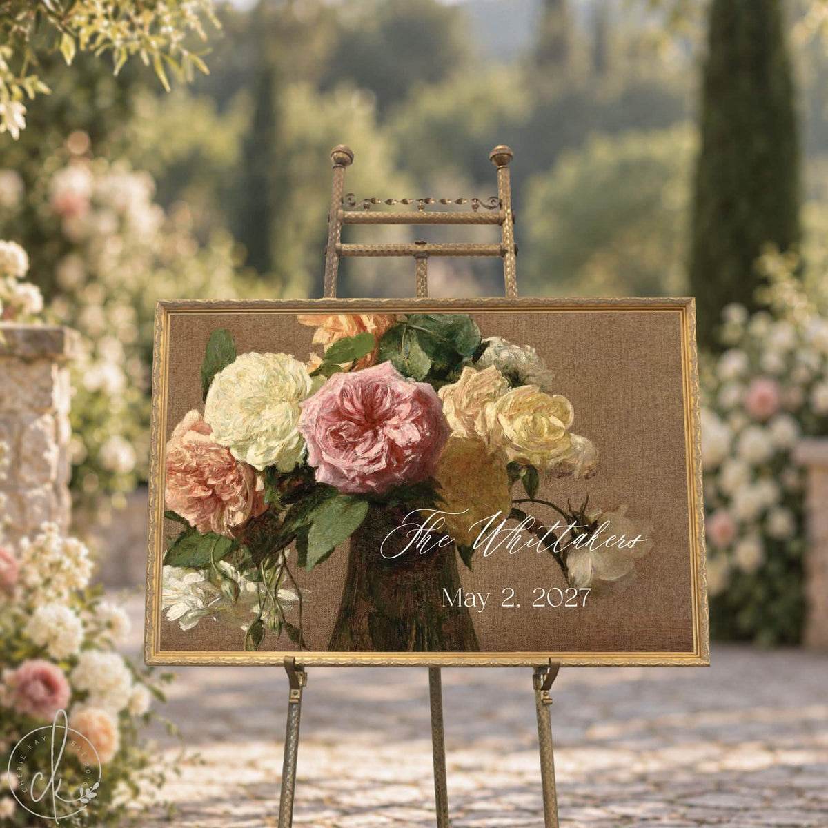 Wedding signs with a last name and date over vintage roses in an ornate gold frame, on a gold easel in a garden