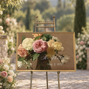Wedding signs with a last name and date over vintage roses in an ornate gold frame, on a gold easel in a garden