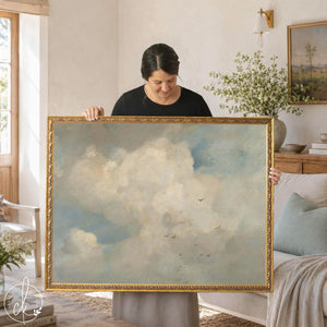 Cloud artwork of white clouds and pale blue sky in an ornate gold frame, held up in a living room