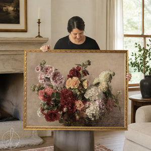 Vintage floral print of pink, red and peach hollyhocks with white garden flowers on taupe canvas in an ornate gold frame