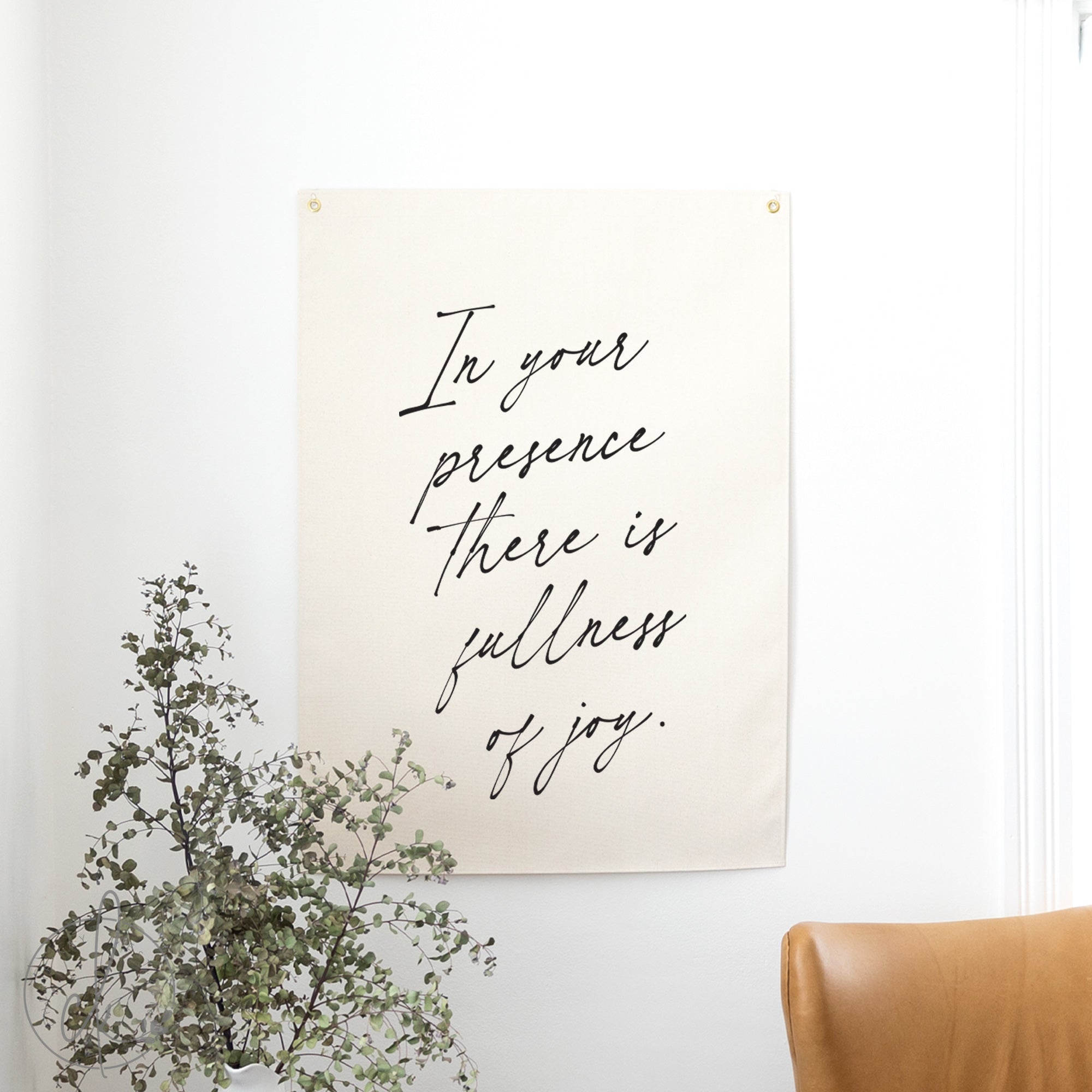 Poster with motivational quote on a wall with a plant and chair in the foreground