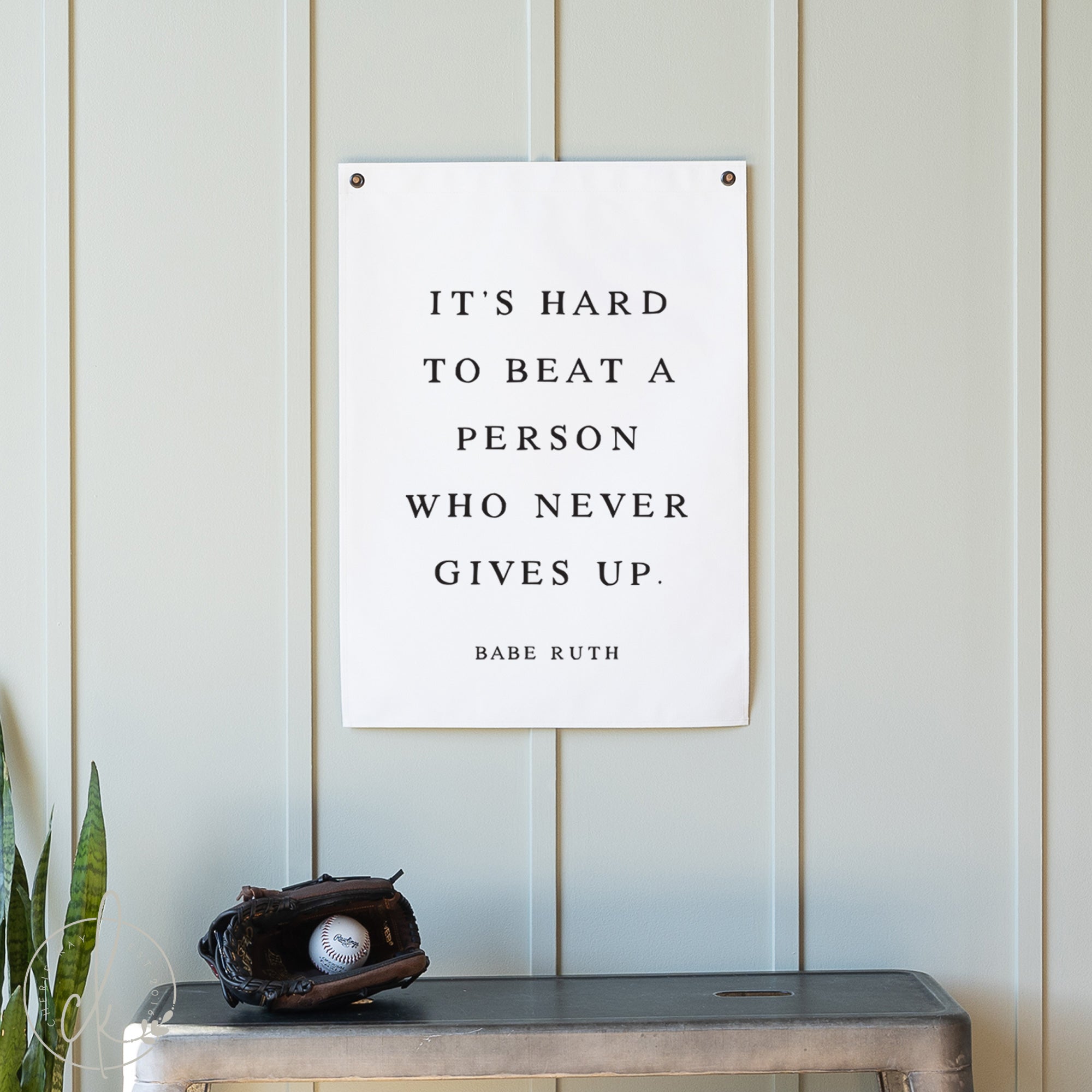 Motivational poster with Babe Ruth quote on a wall with a baseball glove and ball below.
