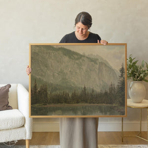 Lake and mountains painting in gold frame showing alpine landscape with pine trees reflected in calm water, vintage oil painting style artwork for wall decor