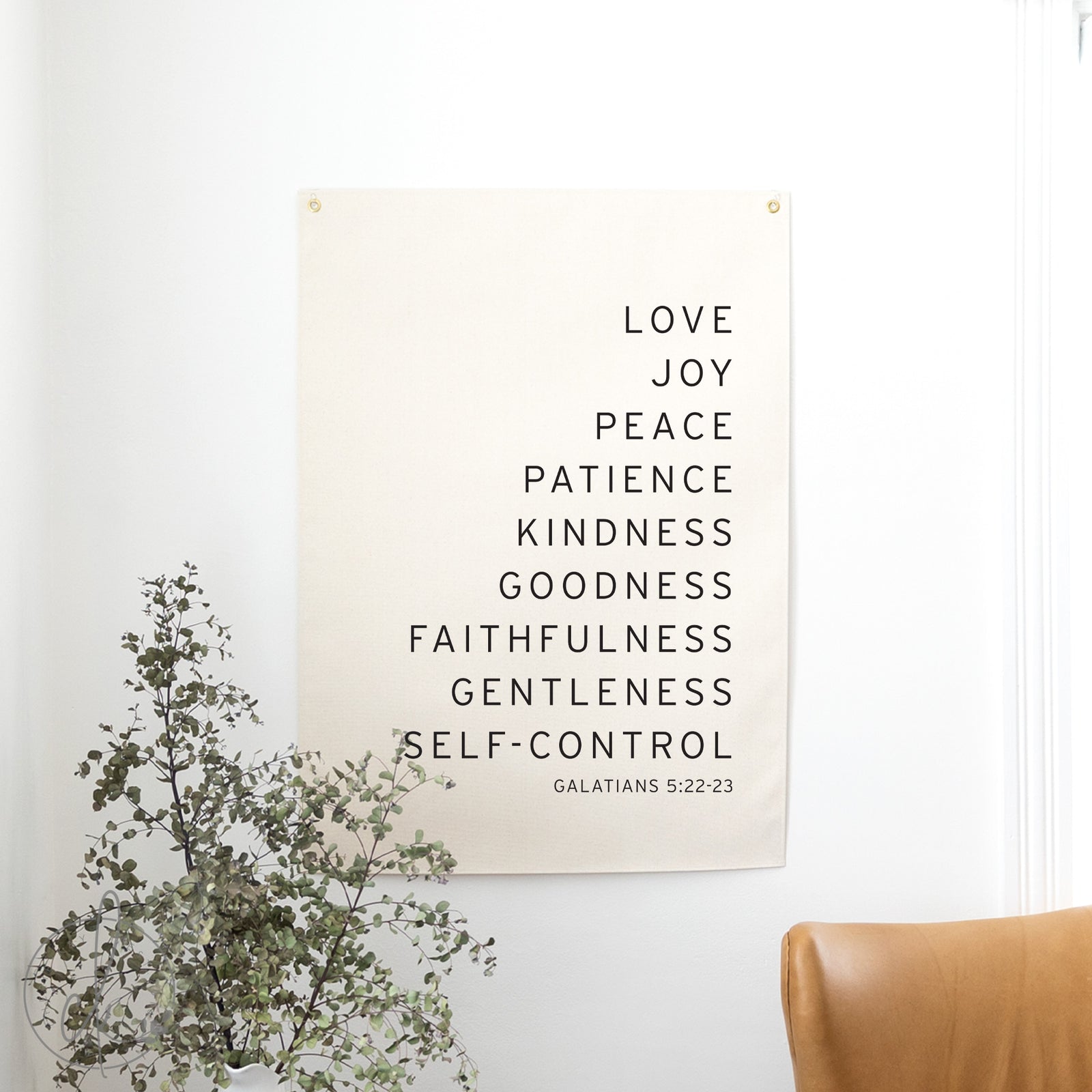 Poster with motivational text on a wall with a plant and chair in the foreground