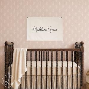 Nursery name banner canvas flag with baby girl's name in cursive script on cream canvas with grommets