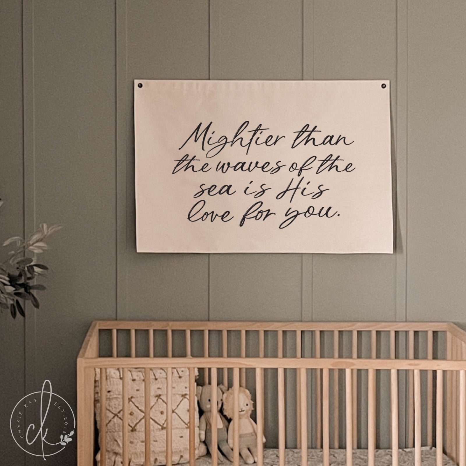 Nursery room with a crib and motivational quote on the wall.