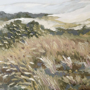 Close-up of abstract watercolor meadow canvas print showing windswept grasses in muted gold, blush, and olive with dark trees and misty hills beyond.