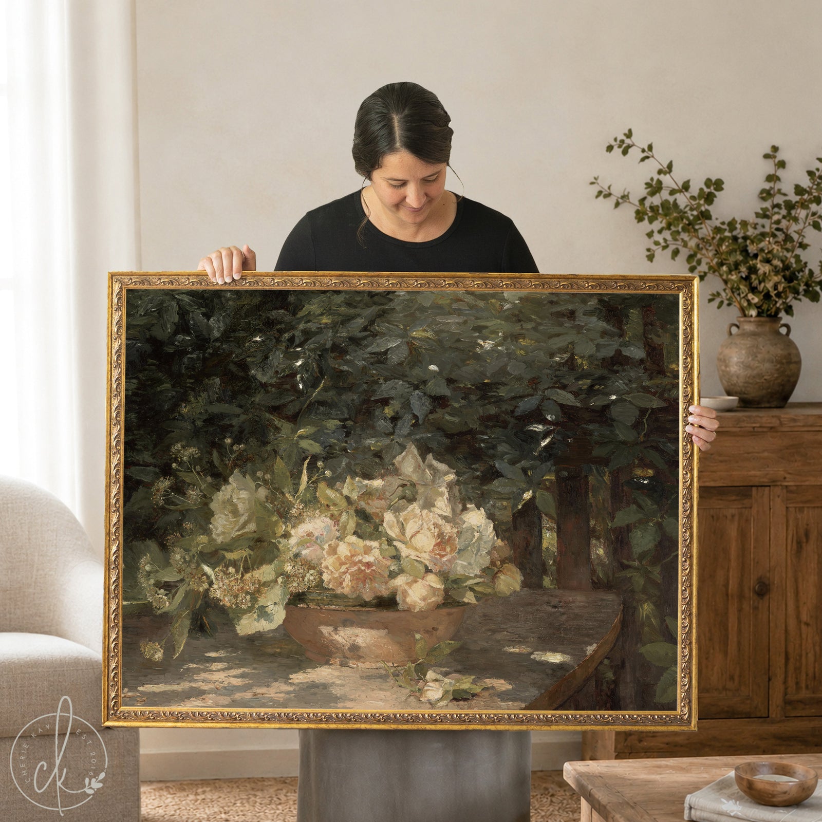 Woman holding Antique botanical art print with flowers in gold frame. 