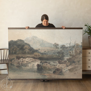 Large framed vintage landscape artwork featuring a serene countryside scene with mountains, trees, and a reflective river in muted earthy tones.