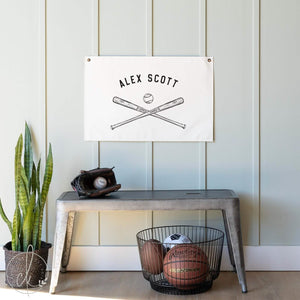Personalized baseball wall art canvas with custom name and a ball and bat graphic, hanging in a kids room.
