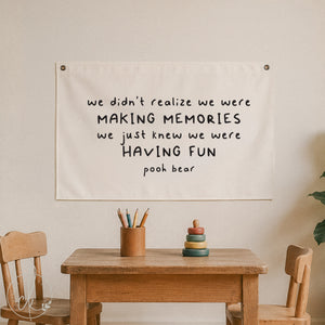 Canvas wall sign with Pooh Bear quote - we didn’t realize we were making memories, we just knew we were having fun - displayed in a cozy kids' room with wooden chairs, table, and soft toys, perfect for nursery, playroom, or children's decor.