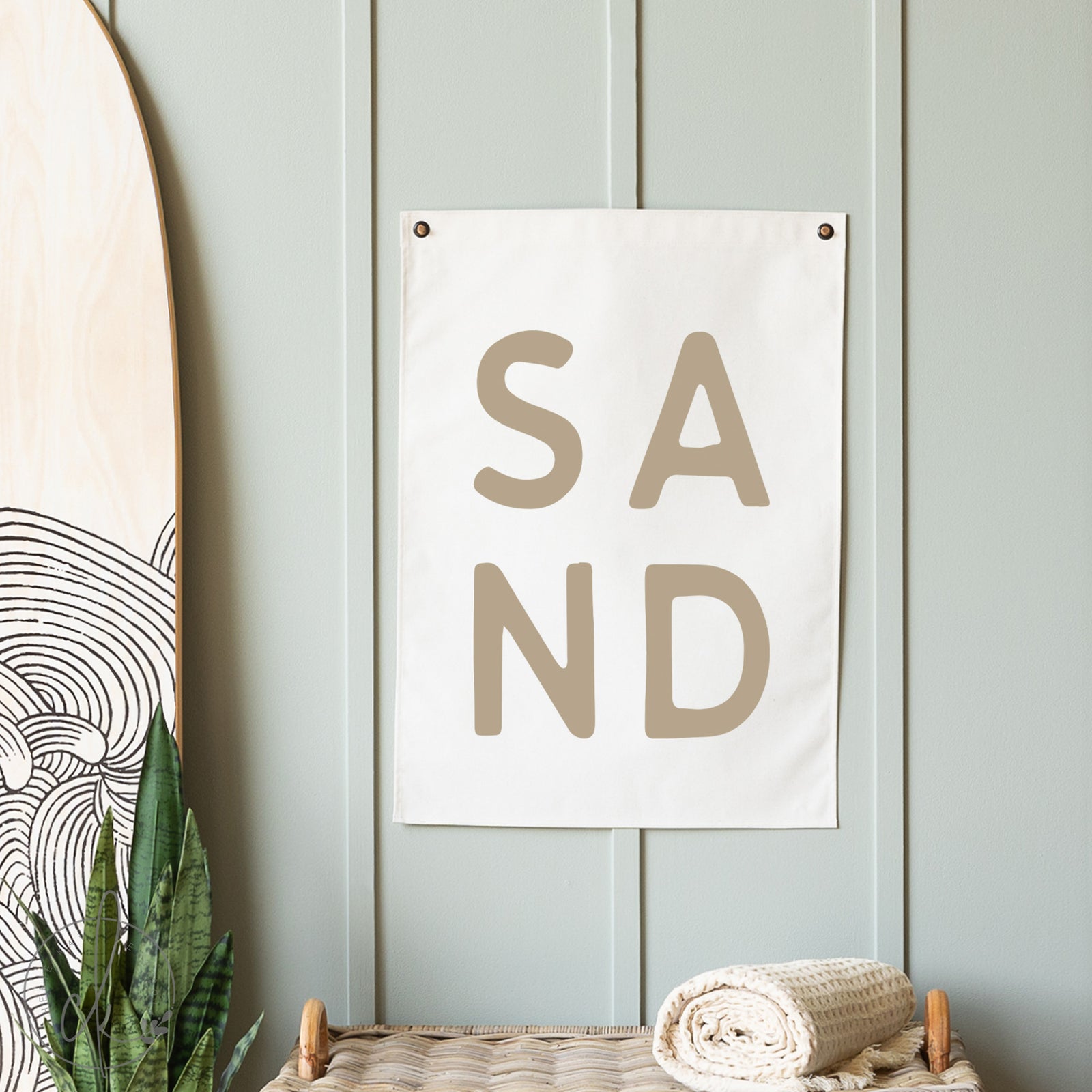 Poster with 'SAND' text on a light blue wall with decorative elements.